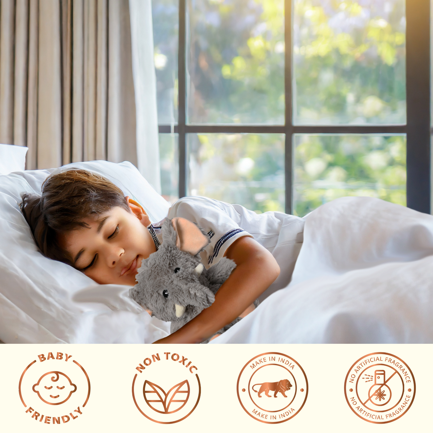 Child sleeping in bed hugging a gray microwavable comfort plush elephant by SOUL for cozy warmth